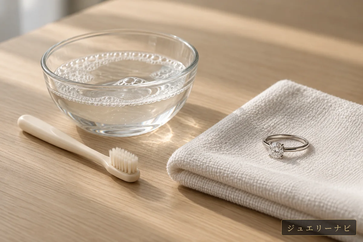 中性洗剤を溶かしたぬるま湯とやわらかい歯ブラシ、布の上の指輪(イメージ)
